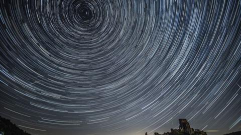 A long exposure shot of a meteor shower has produced streaks of white lines in a circle in the night sky