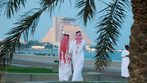 Men walk along Doha corniche (file photo)