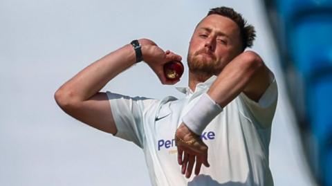 Ollie Robinson bowls a ball