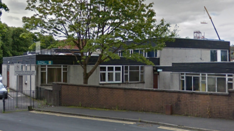 a screengrab from google maps of a grey school building with a green sign that reads St Mungo's Primary School