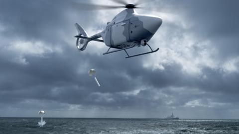 A computer impression of the autonomous helicopter hovering over the sea, dropping "sonobuoys" into the water to listen for submarines.