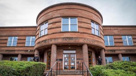 Falkirk Sheriff Court. A brown building with a round entrance.