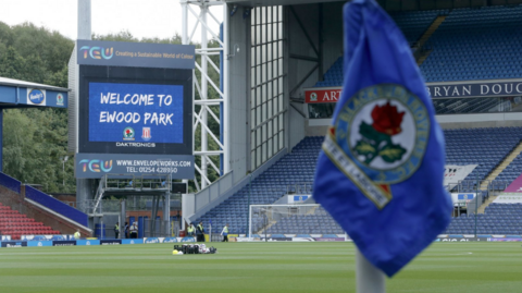 A general view of the inside of Blackburn Rovers' Ewood Park stadium, with a close-up blurred corner flag in the foreground and the pitch further out