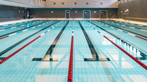 Empty swimming pool. Can see all eight lanes.