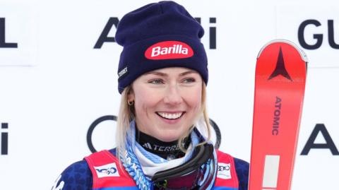 Mikaela Shiffrin poses with her skis after a race