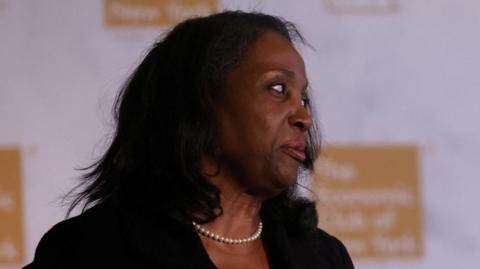 Woman wearing pearls turns her head to the left