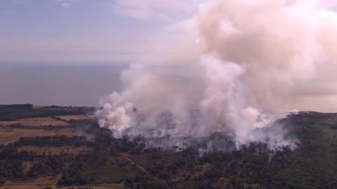 Smoke billows into the air from a wildfire