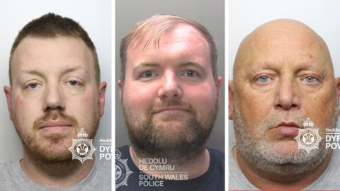 Three mugshots side by side, all are white men. The man on the left has brown hair and a beard and is wearing a grey t shirt. The man in the middle has brown hair and beard and is wearing a navy t shirt. The man on the right is slightly older than the other two and is bald with a greay beard, wearing a grey t shirt.
