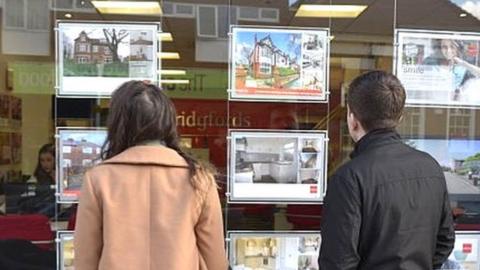 People looking in estate agents window