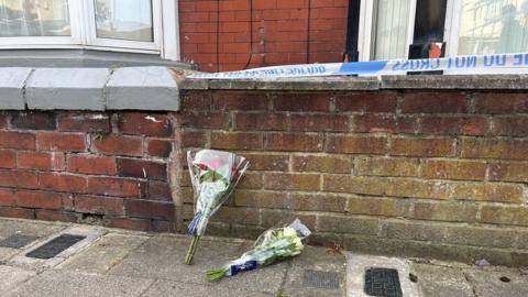 Flowers next to police tape