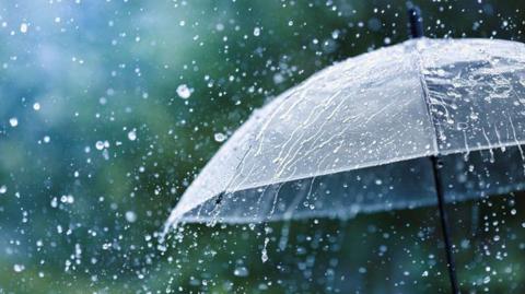 Raindrops splashing onto of a transparent umbrella.