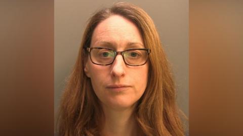 Police custody image of Fiona Phippen. She has long brown hair and is wearing spectacles. She is looking directly at the camera.