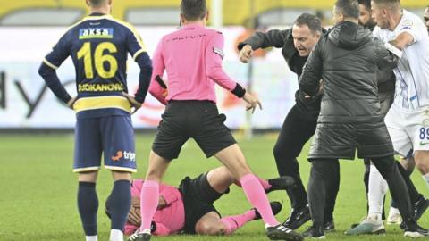 Referee Halil Umut Meler falls to the ground after Faruk Koca, President of MKE Ankaragucu throws a punch at him