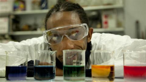 Presenter Jon Chase looking at different coloured chemicals.