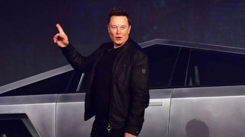Elon Musk standing in front of the all-electric battery-powered Tesla Cybertruck