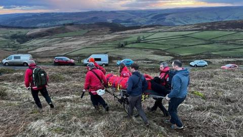 Members of the Edale Mountain Rescue Team help a paraglider