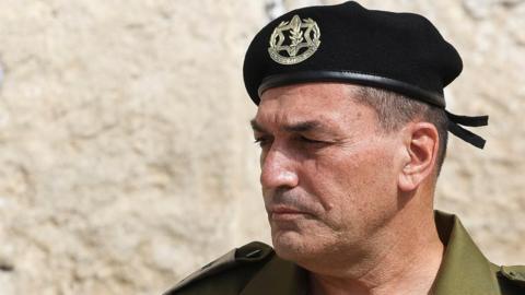 Lieutenant General Eyal Zamir stands near the Western Wall in Jerusalem's Old City,  wearing a black beret with the IDF insignia and a kahki shirt. 