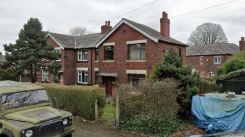 Street view picture of the house whose planning permission for HMO status has been rejected by Bolton Council. The front door is on the left alongside three street-facing windows. They have a front garden and hedges around the property