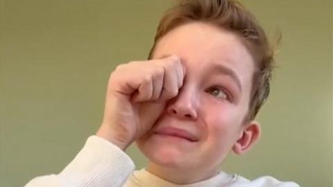 Boy rubs his eye as he makes tearful announcement in video