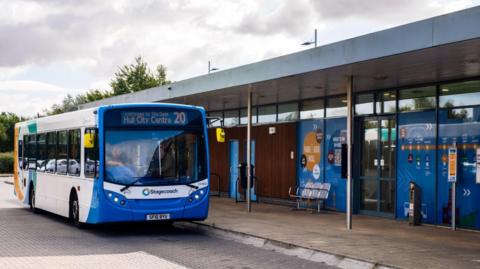 The photo shows a Stagecoach bus outside of a bus stop. The bus is white with orange, green and blue markings. The bus is facing the camera at an angle and reads 'Hull City Centre 20' above the window.