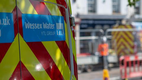 The back of a Wessex Water van. Roadworks are out of focus in the background on the right.