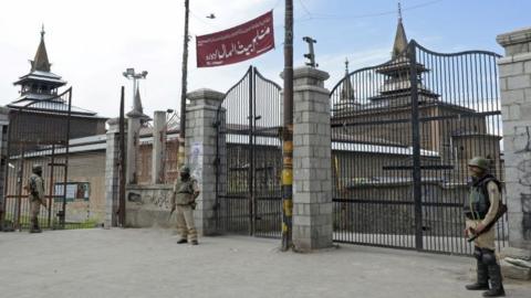 Indian paramilitary troopers stand guard outside Jamia Masjid during a curfew and strike called following the killing of a Kashmiri student in downtown Srinagar on June 9, 2017