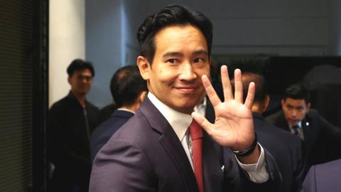 Pita Limjaorenrat of Thailand's Move Forward Party waves to cameras after unveiling his coalition