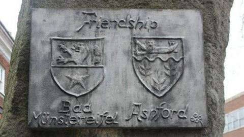 A plaque that says "friendship" above the coat of arms of both Ashford and Bad Münstereifel