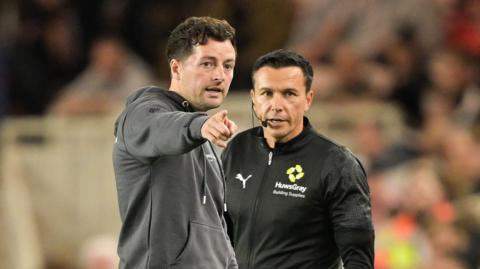 West Brom head coach Ryan Mason pointing at something while in discussion with the fourth official during the defeat to Middlesbrough. 
