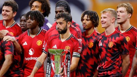 Manchester United players stand next to the Premier League Summer Series trophy