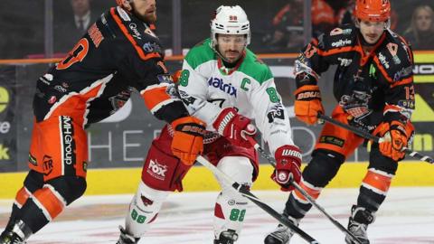 Cardiff player tussling with two Sheffield players.