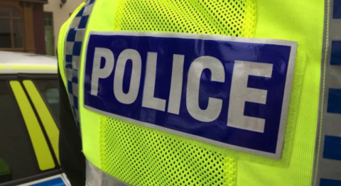 A yellow police vest with the word police.