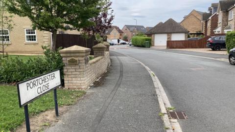 A street view of Portchester Close. It is a curved street with newly built detached houses.