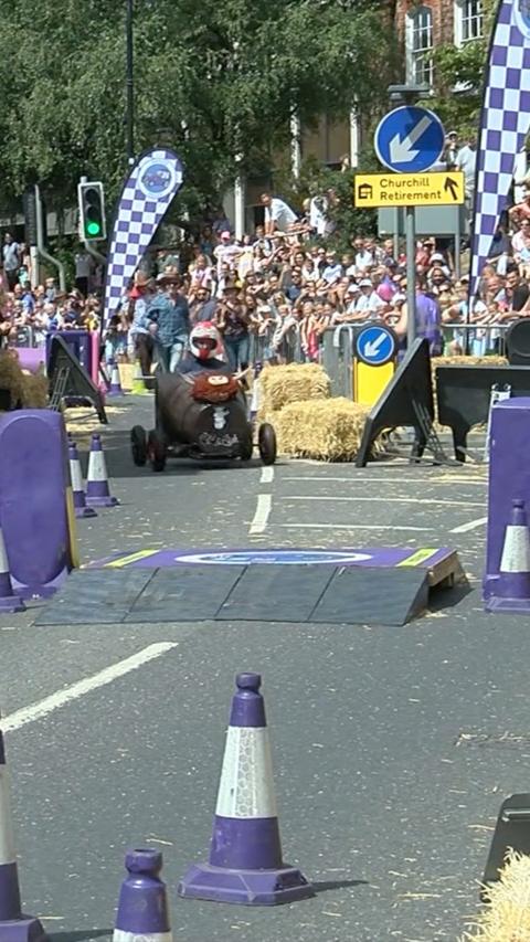 A soapbox car driving through Newbury town centre.