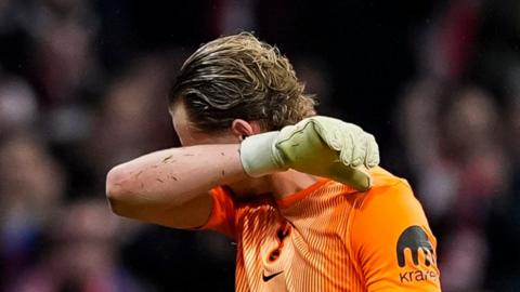 A goalkeeper with his face covered