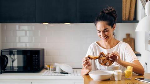 Woman eating in kitchen
