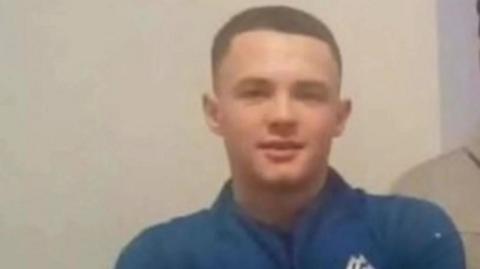 Harry Gilbertson, wearing a blue sports top, looks ahead in a photo