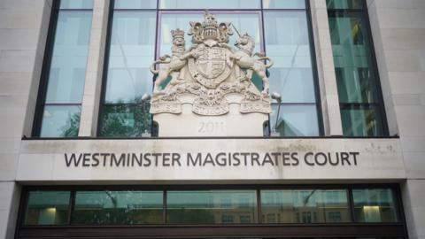 A general view of the entrance to Westminster Magistrates Court. The name of the court is written on the front of the building above an entrance. The HM Courts and Tribunal Service emblem rests above the court name.