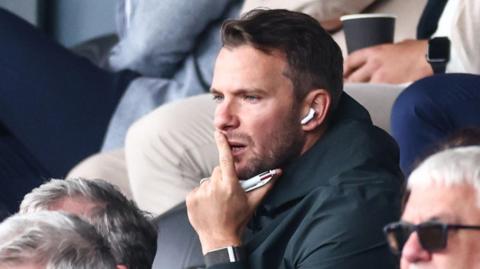 Tom Cleverley watches the game from the Director's Box at Burton Albion