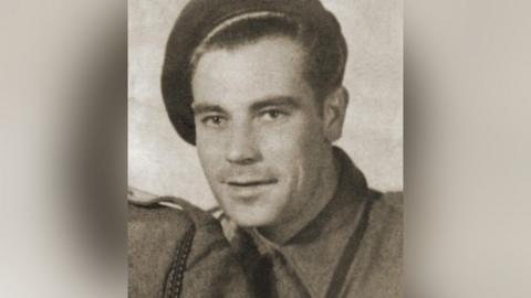An old black and white photograph of Alfred Ernest Latham. He is wearing an SAS uniform, including a cap. He is looking direct into the camera. 