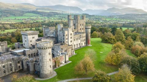 The neo-Norman grey brick Penrhyn Castle is surrounded by gardens and woodland