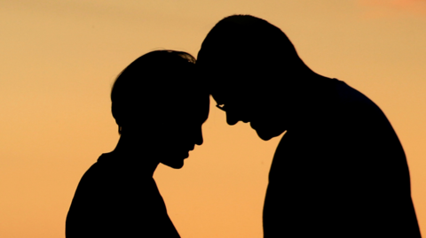 Generic silhoutte of a man and a woman with their foreheads touching