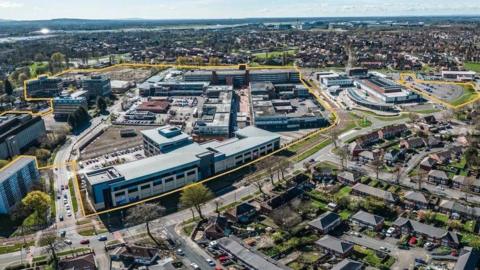 An aerial shot of Wythenshawe town centre with yellow lines tracing the outline of a former shopping centre and car park area which is earmarked for redevelopment. 