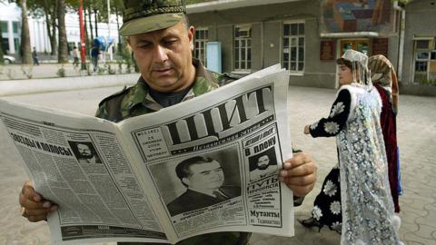 A Tajik military officer reads a newspaper, featuring President Emomali Rakhmonov on the front page, in Dushanbe, 28 October 2006.