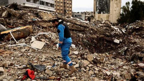 A paramedic walks among the rubble at a site damaged in an Israeli strike, amid escalating hostilities between Israel and Hezbollah, as the U.S.-Israeli conflict with Iran continues, in Nabatieh, Lebanon, March 25, 2026.