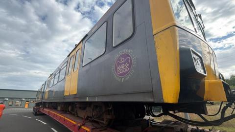 The Royal Train with Queen Elizabeth's purple Platinum Jubilee insignia is transported on a red lorry bed to The North East Land, Sea and Air Museum in Washington.