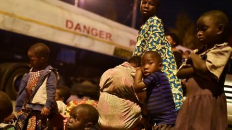 People gather with their belongings following a volcanic activities at Mount Nyiragongo near Goma