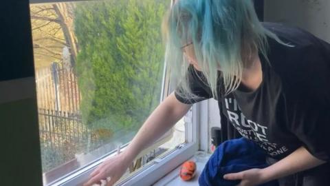Lauren Yeo cleans mould off the window