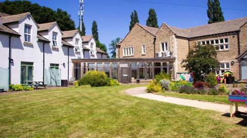 Exterior image of a hospice building set in landscaped gardens.