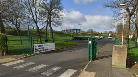 The entrance to Prudhoe Community High School with a panel to one side and a poster saying "attendance matters". 